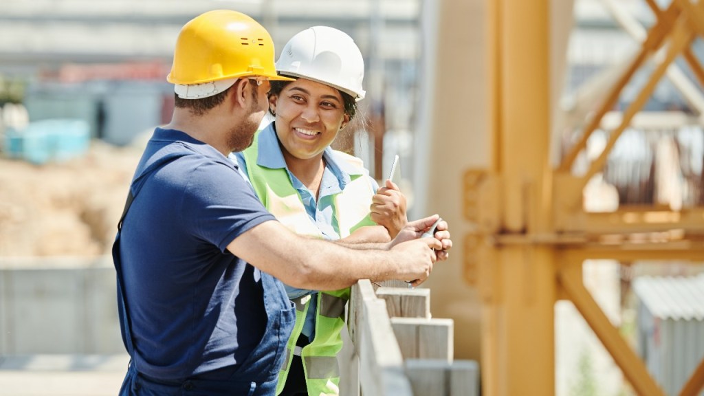 Two construction workers on a site wearing hard hats that can now be recycled with TerraCycle.
