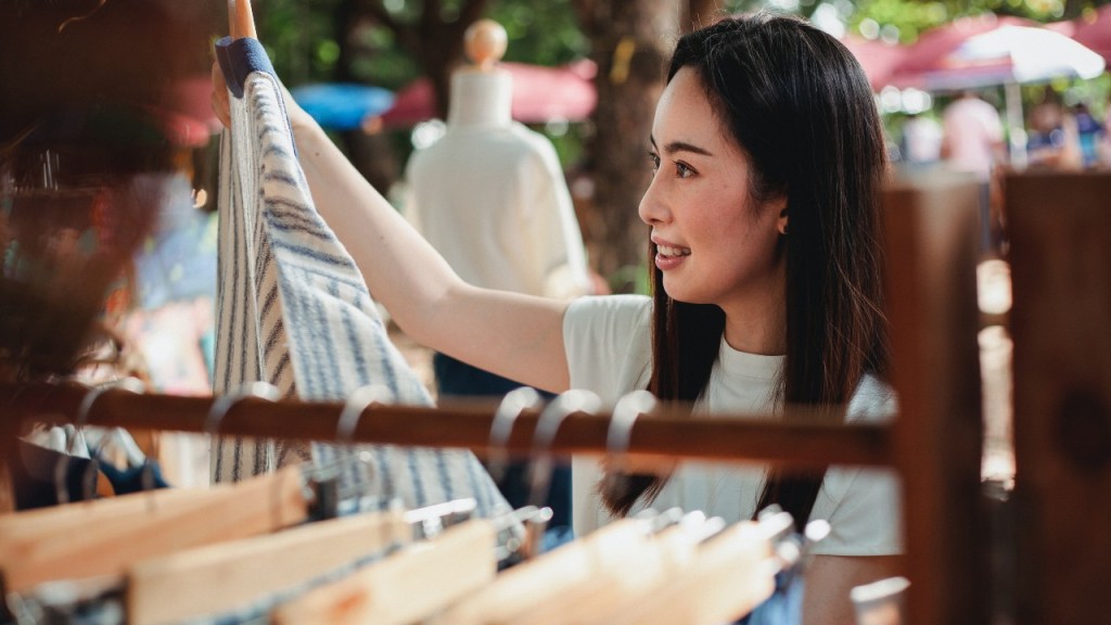 Young woman looking at secondhand clothes at a zero-waste fete.